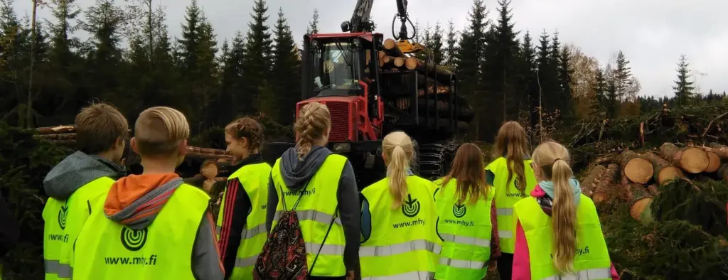 Kuvituskuva. Nuoret kouluretkellä ja katsovat metsän hakkuuta.